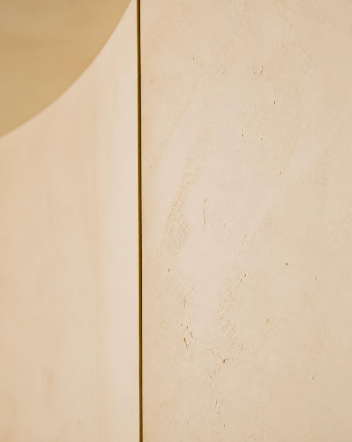 Detalle arquitectónico de muro de piedra clara con una línea de sombra
